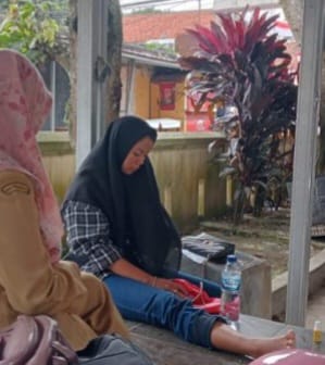 Korban Anglea Adithia Sarean yang mengalami kecelakaan, dan polisi dibantu warga sedang mengevakuasi sepeda motor yang terjun ke jurang di Jalan Raya Pandeglang-Labuan tepatnya di Kampung Ciekek, Kelurahan Pandeglang, Kecamatan Pandeglang, Provinsi Banten, Senin 27 Mei 2023. (Foto: istimewah)