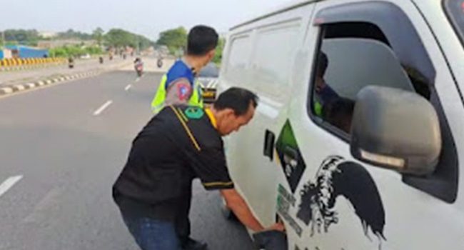 Jajaran Polsek Karawang, membantu sopir yang kehabisan BBM di Flyover Lamaran Atas, Kabupaten Karawang, Rabu 19 April 2023. (Foto: Andika)