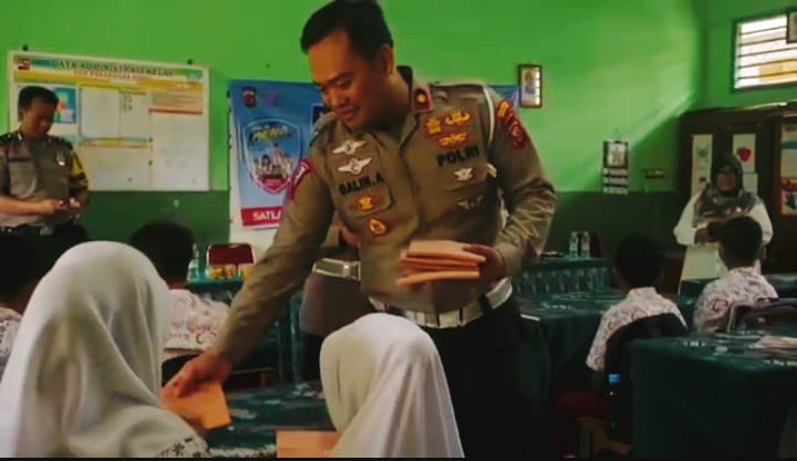 Kasat Lantas Polresta Bogor Kota Membagikan Buku dan Alat Tulis Kepada Murid-Murid. (Foto : Fathar)