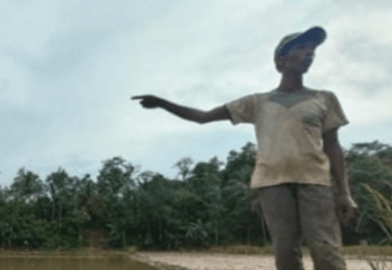 Seorang petani warga Desa Mekarjaya, menunjukkan lahan pertanianya yang terdampak oleh limbah dari penambangan galian pasir. (Foti: istimewah)