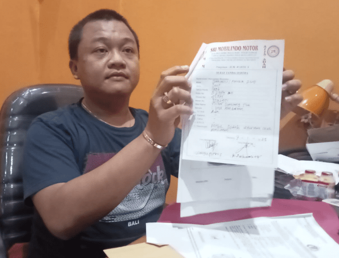 Wahyu Putro Santoso, pemilik showroom mobil saat menunjukkan berkas transaksi jual beli mobil kepada oknum Kades. (foto: Abdul Kholilulloh)