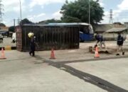 Truk Kontainer Muatan Keramik Terguling di Tikungan Gerbang Tol Telaga Asih